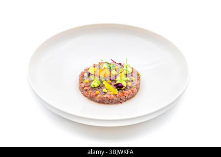 Meat tartare with quail eggs on a white porcelain plate Stock Photo