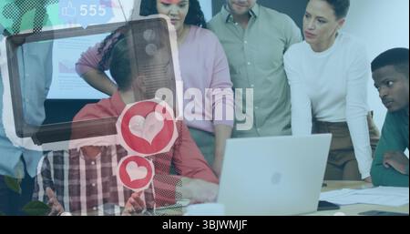 Six colleagues in business attire collaborating around laptop in meeting room, with digital overlay Stock Photo