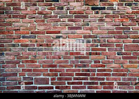 Rustic Red Brick Wall Texture. A detailed image of a rustic red brick wall showcasing various shades and textures. Stock Photo