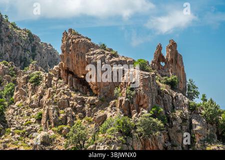 A dramatic rock formation with a heart shaped hole at the Calanches de Piana, a UNESCO heritage site on the west coast of the Mediterranean island of Stock Photo
