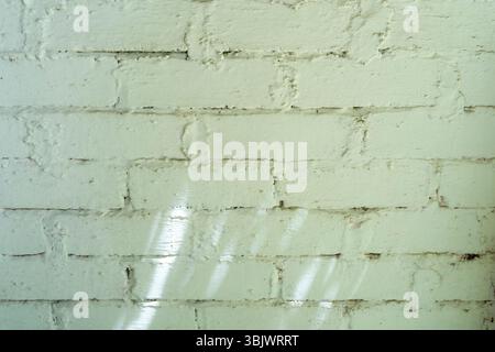 Brick wall with a rough texture and a few holes. The wall is made of gray bricks and has a somewhat worn appearance Stock Photo