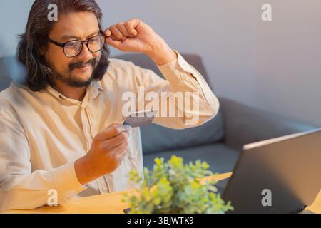 Smiling businessman with laptop and making payment with credit card. Internet banking concept. Businessman or entrepreneur working, Online shopping. Stock Photo