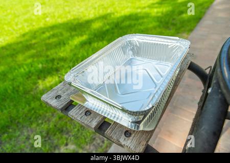Deep aluminum foil grill tray, garden view Stock Photo