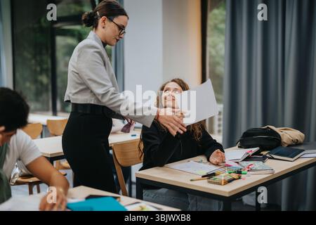 Teacher interacting with students in a modern classroom setting Stock Photo