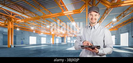 man using digital tablet large empty warehouse Stock Photo