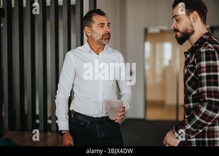 Two business workers having a casual discussion in the office Stock Photo