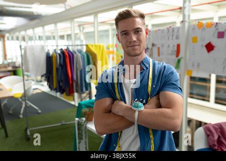 Studio space featuring colorful garments on rack under overhead skylights with design tools Stock Photo
