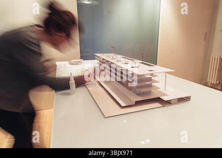 Female architect working on architecture model on table Stock Photo