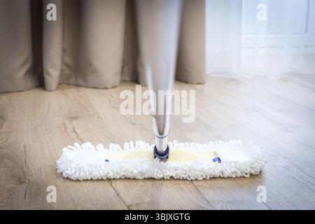 Modern white mop cleaning a wooden floor Stock Photo