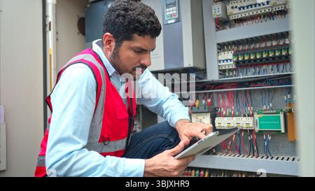 Electrical engineer inspects the electrical control board of a crane before putting it to use on a construction site Stock Photo