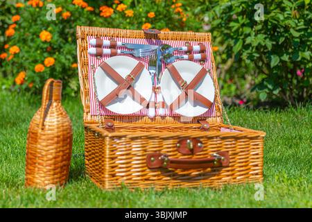 Picnic basket on green sunny lawn in the park Stock Photo