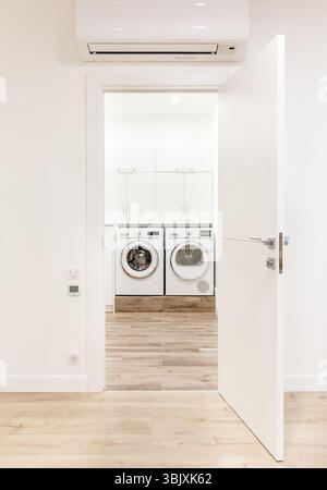 White opened door in modern home with air conditioner and wooden floor Stock Photo