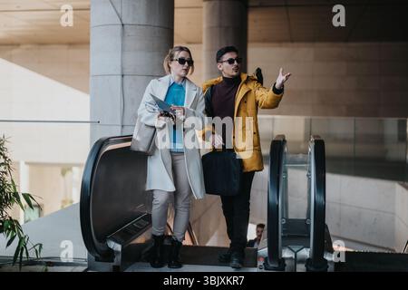 Young professionals collaborating on an urban escalator in business attire Stock Photo