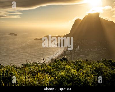 Golden Sunset Over Rio De Janeiro From Two Brothers Mountain: Dramatic Sunbeams Streaming Through Coastal Peaks Above The Atlantic Ocean And Leblon Be Stock Photo