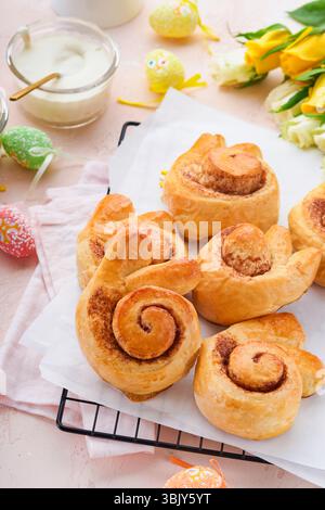 Easter breakfast Holliday concept. Easter bunny buns rolls with cinnamon made from yeast dough with orange glaze, easter decorat Stock Photo