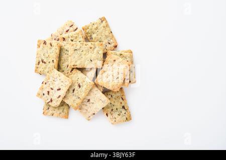 Stack of grain salty crackers with bran and flax seeds on white background. Top view. Stock Photo