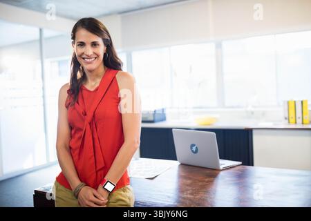 Silver laptop sitting on wooden desk in office kitchen, with bowl of lemons and printer Stock Photo