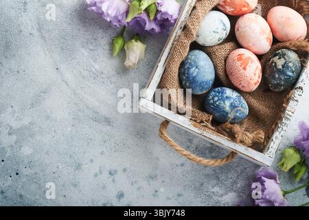 Easter eggs. Dyed Easter eggs with marble stone effect ref and blue color in rustic style on light grey stone background. Easter Stock Photo
