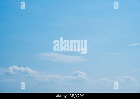 Sky. Blue sky with white clouds background. Curly clouds on a sunny summer day. Light cloudy. Good weather. Simple background sk Stock Photo