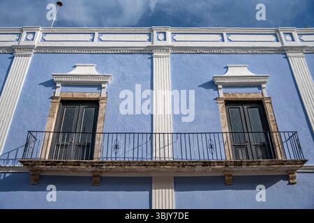 Blue colonial house with white columns and balcony under clear sky in Mexico, Yucatan Peninsula, Campeche historic center. Stock Photo