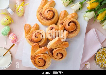 Easter breakfast Holliday concept. Easter bunny buns rolls with cinnamon made from yeast dough with orange glaze, easter decorat Stock Photo