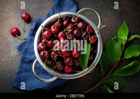Fresh cherry in iron bowl on a dark concrete background for a pie. Selective focus. Top view Stock Photo
