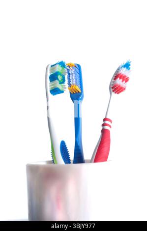 colorful toothbrushes in a glass over white Stock Photo