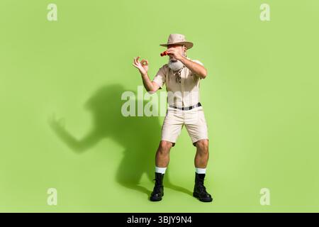 Photo of concentrated scientist man use binocualrs study natural organism wildlife isolated green color background Stock Photo
