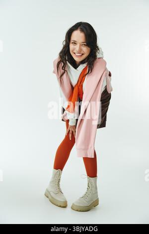 A fashionable young woman showcases her unique style and confidence in a bright setting. Stock Photo