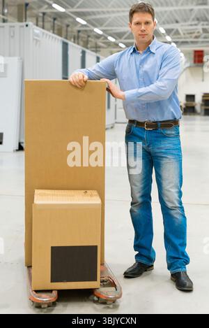 Male worker with boxes at warehouse. Stock Photo