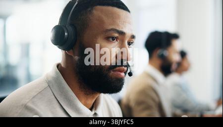 Serious, profile and man in call center for technical support, IT solution or coworking. Headset, problem solving and operator think of virtual Stock Photo