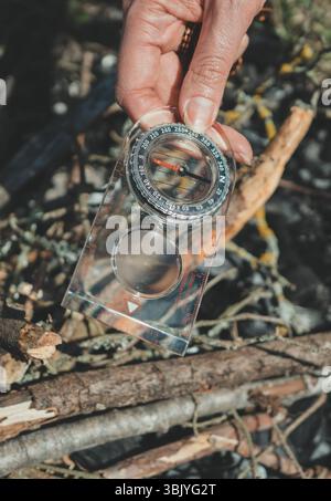 Woman uses a magnifying glass to burn a bonfire. Stock Photo