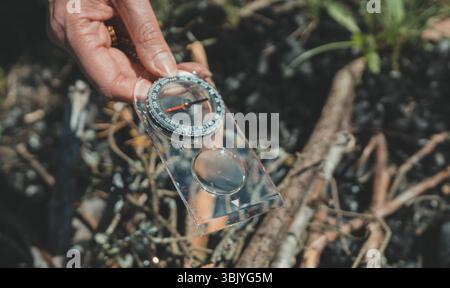 Woman uses a magnifying glass to burn a bonfire. Stock Photo