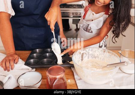 Unrecognizable granny and granddaughter making cupcakes in the kitchen Stock Photo