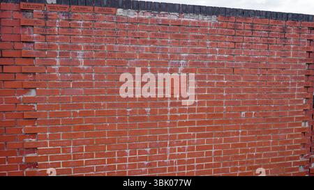 SHEFFIELD, UK - JUNE 13, 2025 - Red commemorative bricks forming a wall with inscriptions, probably names and dates related to donations or important Stock Photo