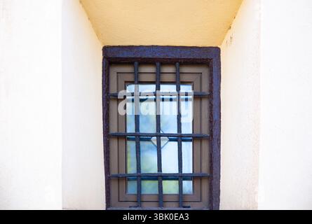 Window with rusty bars in an old building, close-up. Stock Photo