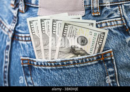Money in denim pocket. Dollar bills sticking out of blue jeans. Financial savings and cash budget concept. Personal finance idea.Hidden stash of money Stock Photo