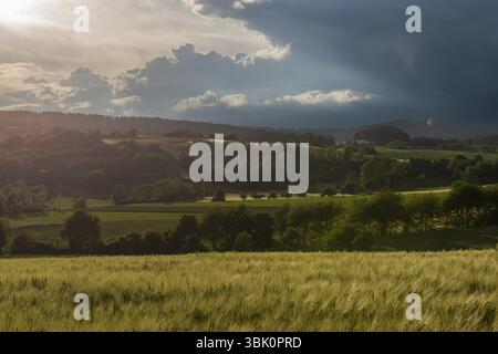 Dramatic cloudy sky with approaching storm and last rays of sunshine, Frankenhain, dark cloud wall, cumulonimbus clouds, thunderstorm in the lift, low Stock Photo