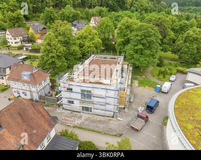 Building under construction with scaffolding, surrounded by trees and construction site vehicles, Hirsau, Calw, Germany, Europe Stock Photo