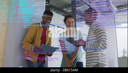 Standing three colleagues reviewing code on panel in office, with tablet, green folder and notebook Stock Photo