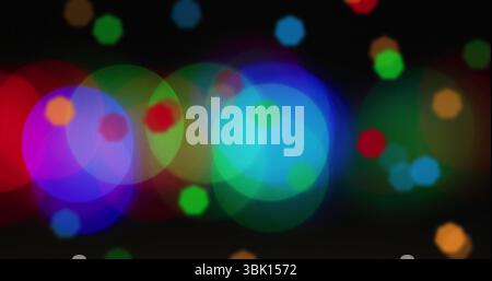 Showing overlapping colored light circles dancing across black background, with abstract bokeh Stock Photo