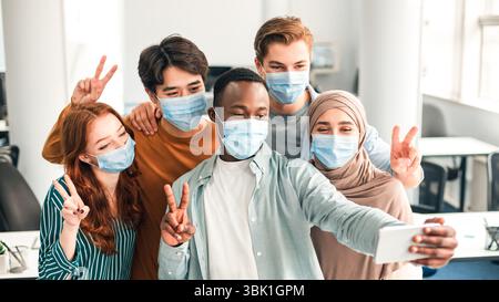 International students wearing medical face masks taking selfie Stock Photo