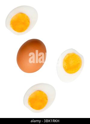Top view set of raw brown chicken egg and cooked or boiled chicken eggs with egg yolk in three halves is isolated on white background. Stock Photo