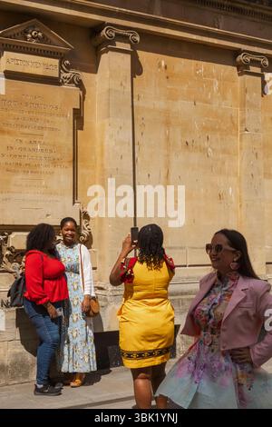 England, Somerset, Bath, Bath Abbey, Colourful Tourists in front of Bath Abbey Stock Photo