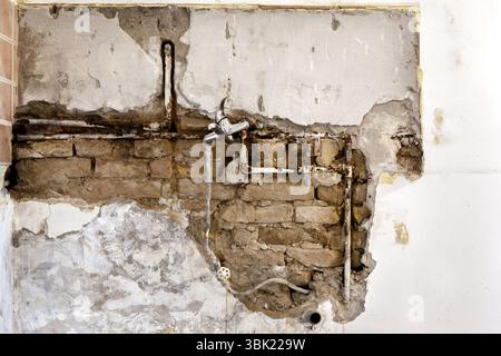 Damaged wall plumbing in a house closeup Stock Photo