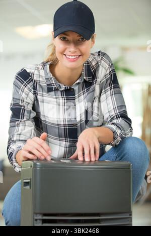 female technician repairing a portable heater Stock Photo