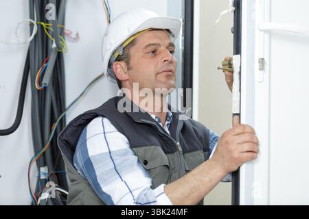 electrician installing energy saving meter Stock Photo