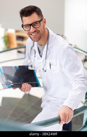 cheerful male doctor walking up the stairs in hospital Stock Photo