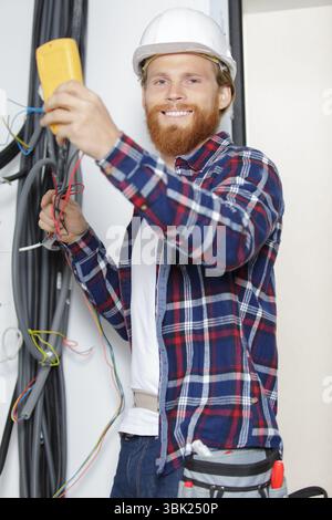 electrician testing wiring installation with multimeter Stock Photo