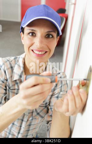 happy woman using screw driver during socket installation Stock Photo